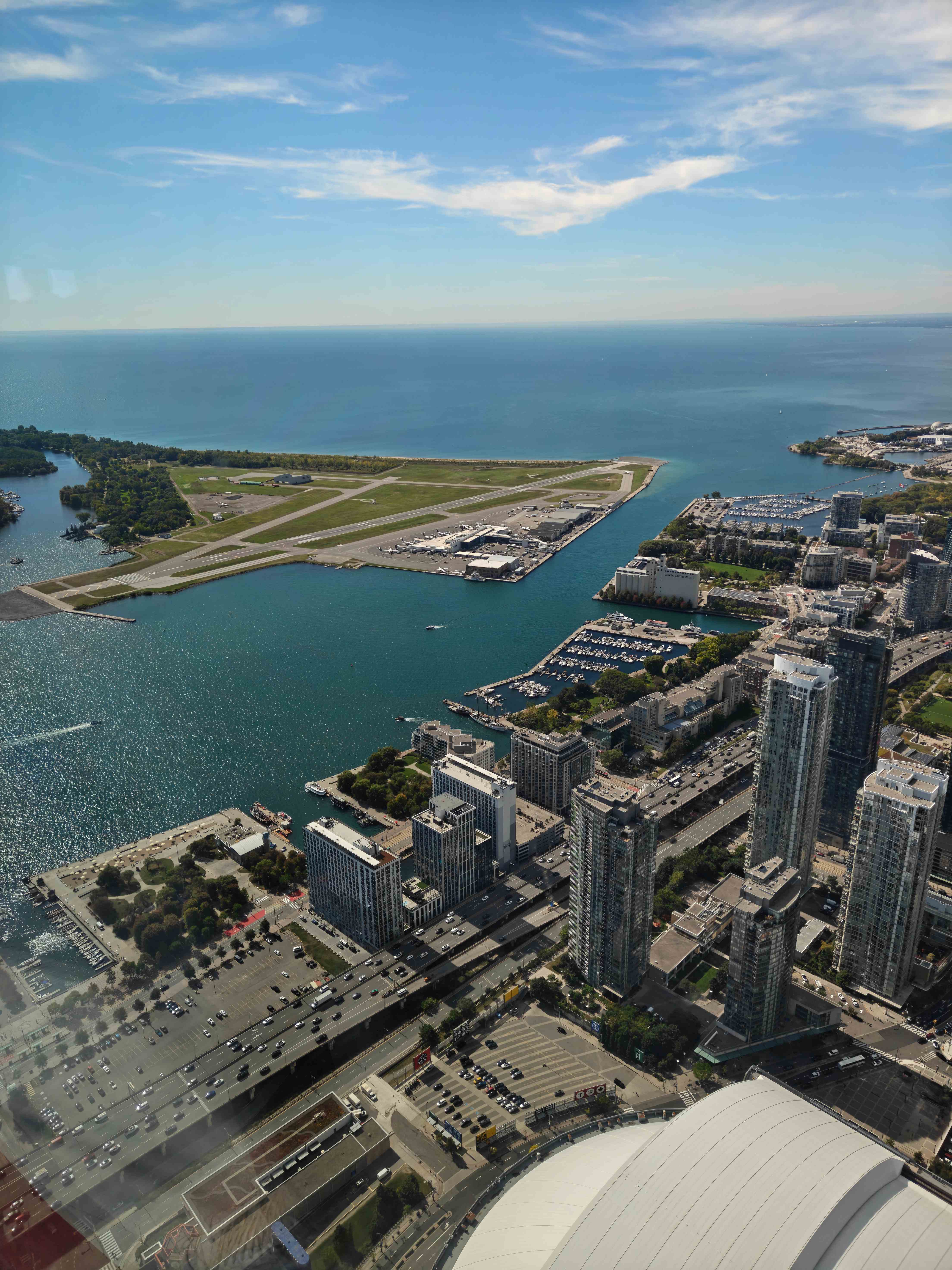 Vista aérea de una ciudad costera con puerto, aeropuerto y edificios urbanos