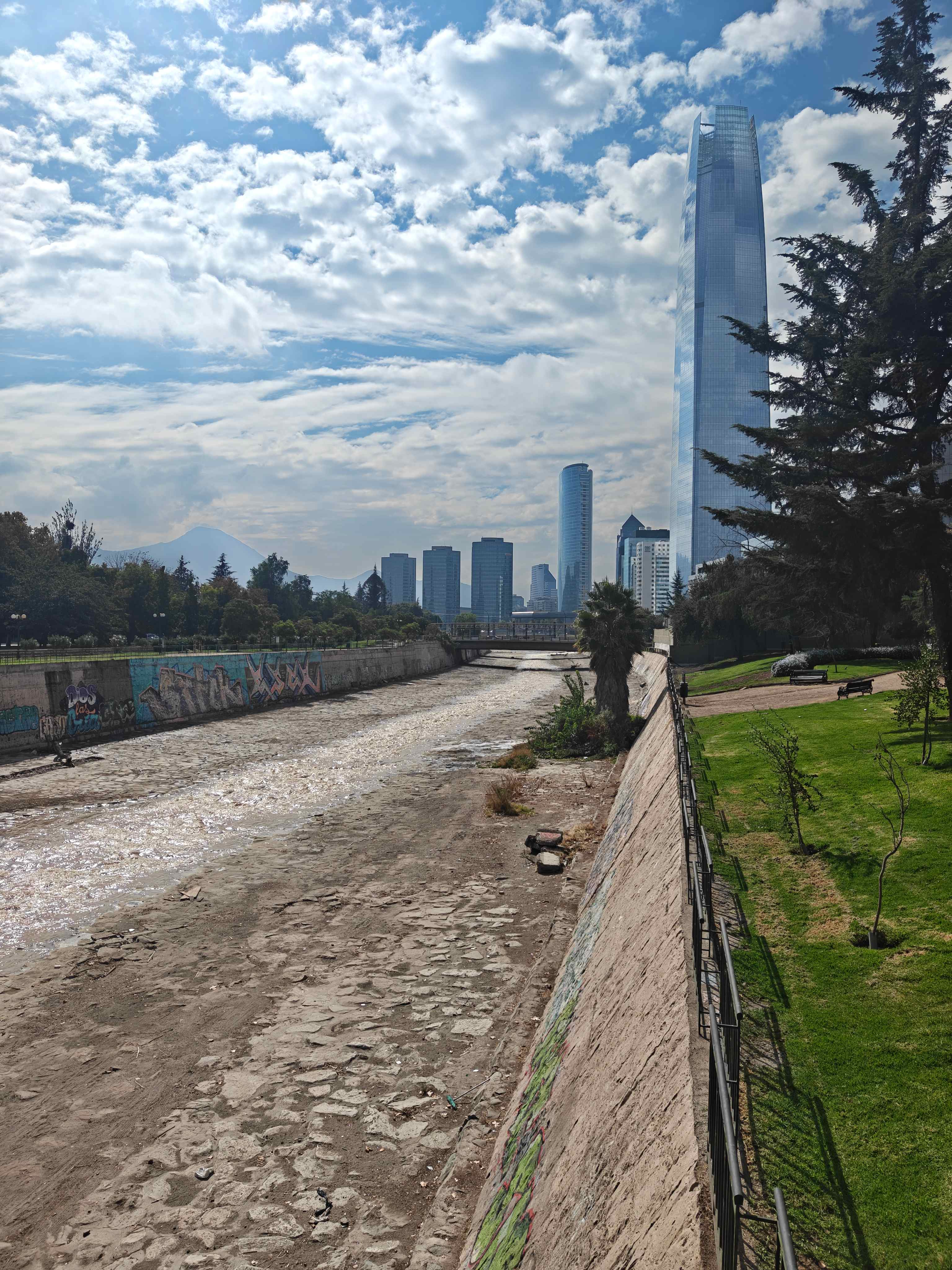 Vista urbana junto a un río con parque, infraestructura y edificios